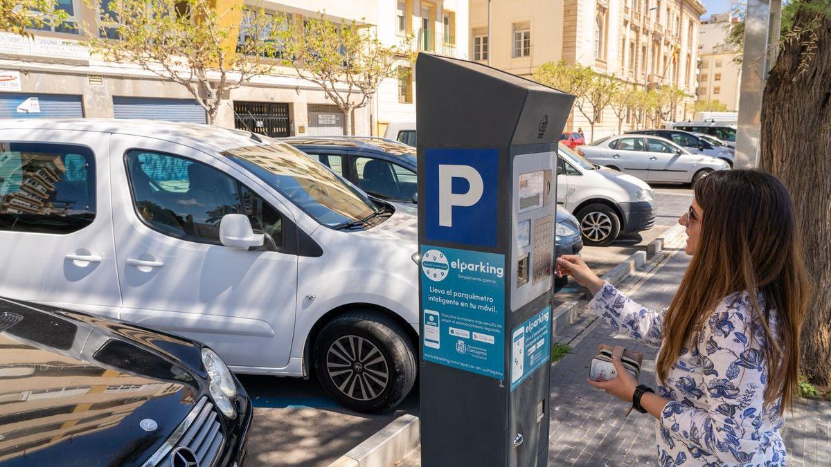 Una conductora echa monedas a la máquina de la ORA en Cartagena