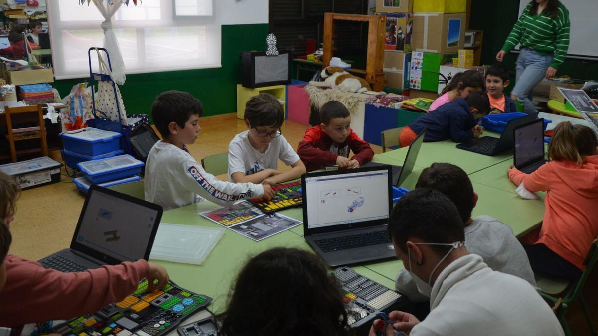 Nes semeyes, neños del taller de robótica «Tardes Gayoleres», armando los robots  y programándolos pa facer que sigan les sos instrucciones.