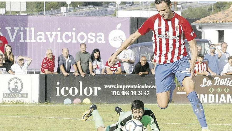 Borja Viguera regatea a Asier Riesgo en la jugada del segundo gol del Sporting.