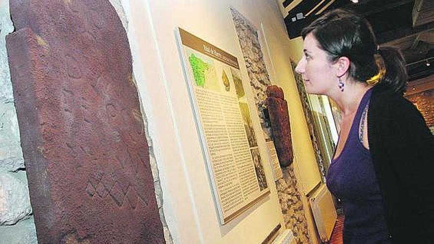 Una visitante observa las estelas romanas del Museo del Territorio de Ribadesella.