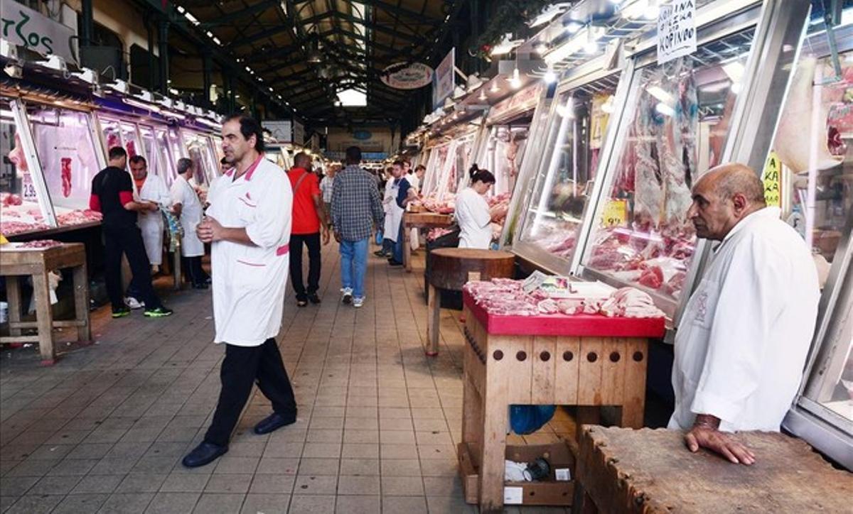 Carniceros esperan clientes en sus puestos del mercado central de Atenas.