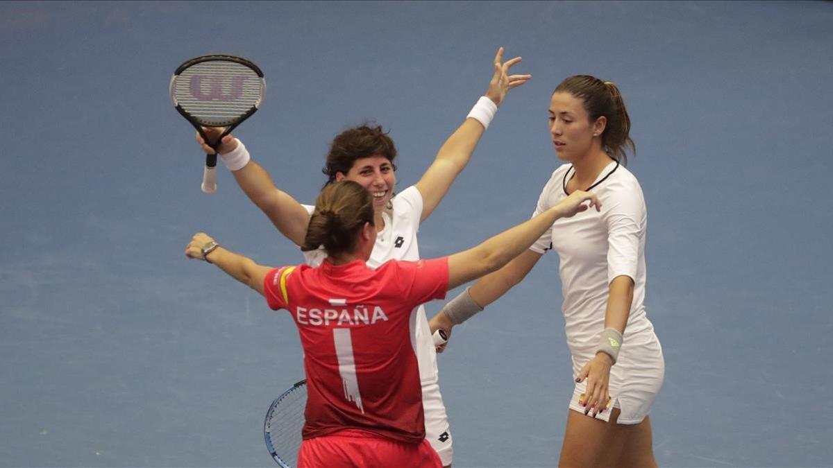 Carla Suárez y Garbiñe Muguruza se abrazan a la capitana Anabel Medina tras la victoria