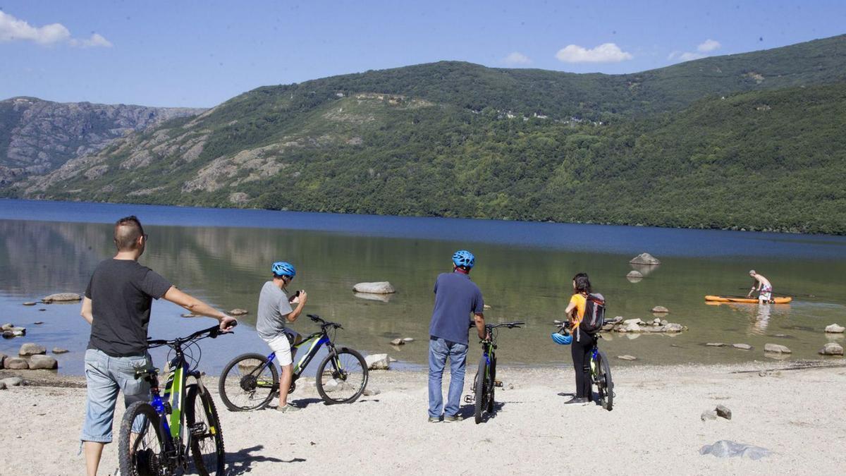 Un grupo de personas en bicicleta en una de las playas del Lago de Sanabria