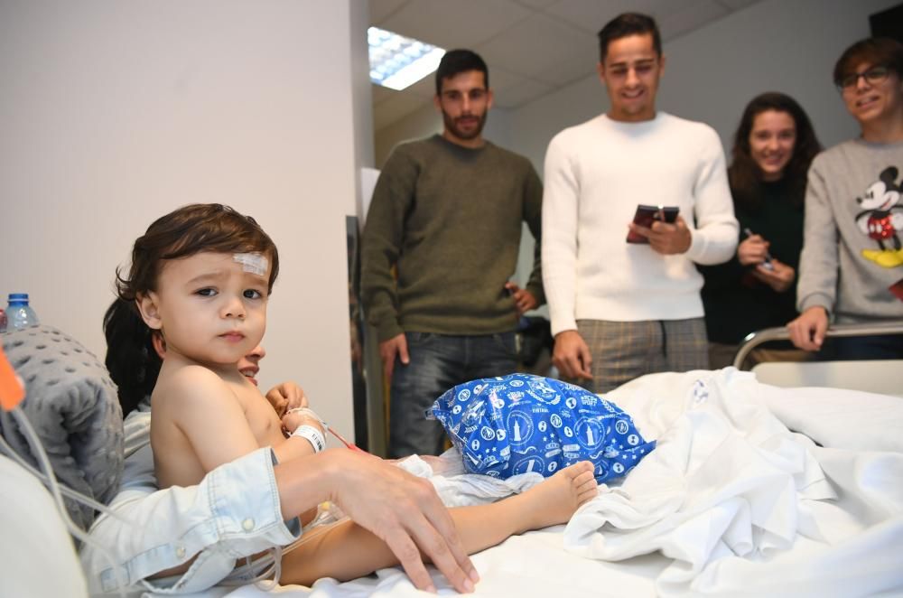 Dos futbolistas del primer equipo -David Simón y Eneko Bóveda-, junto a tres jugadoras del Deportivo Abanca -Cris, Laura y Miriam- visitam a los niños hospitalizados.