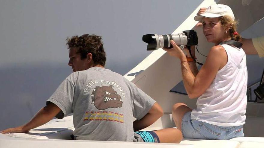 La Infanta Elena, junto a Froilán, haciendo fotografías del evento.