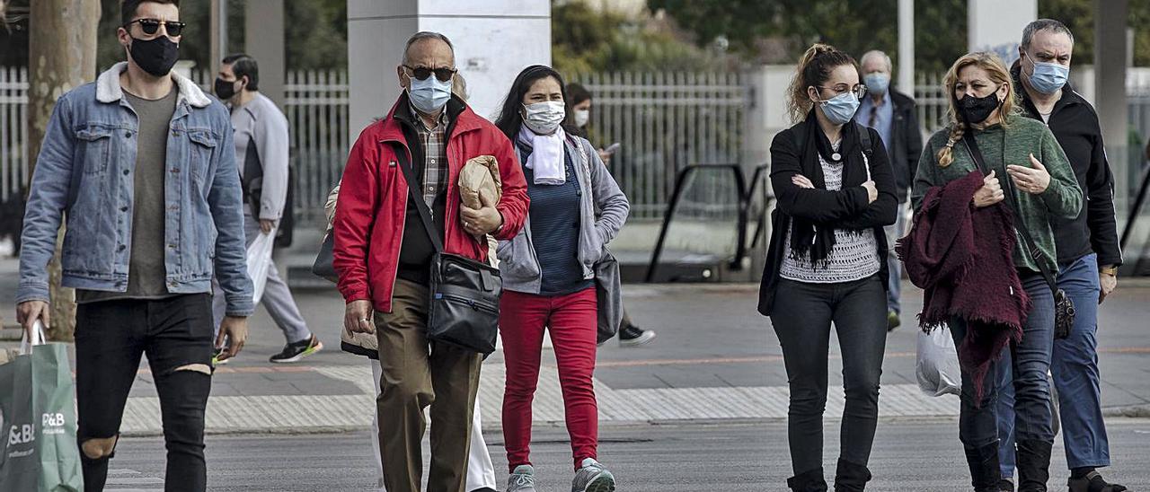 Ciudadanos con mascarilla cruzan las Avenidas de Palma. | B. RAMON