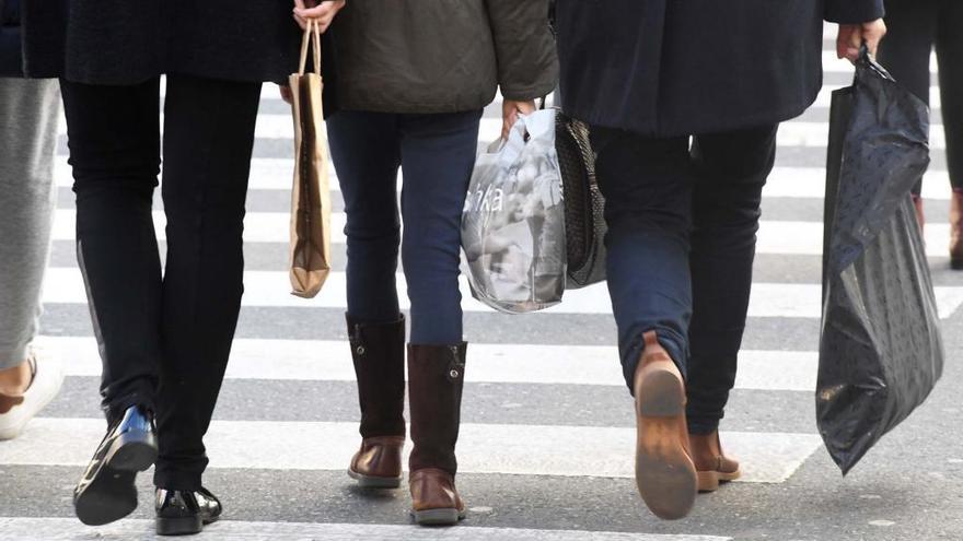 Varias personas con bolsas de compras en A Coruña.