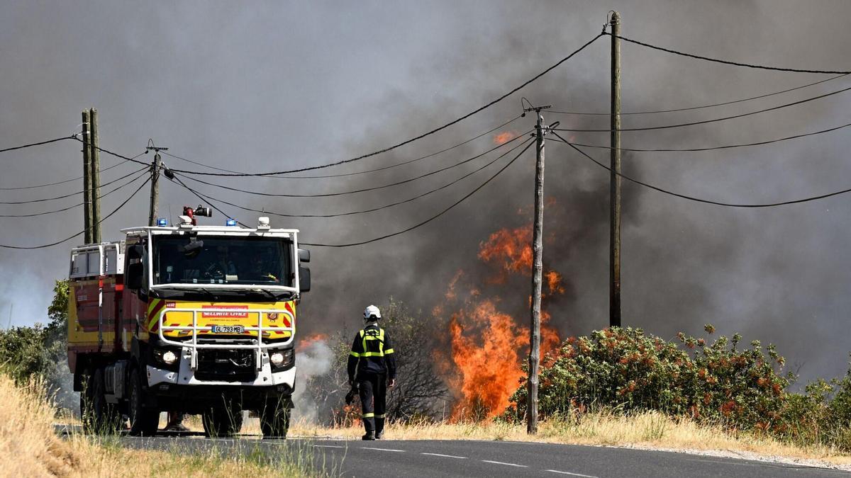 Un bomber francés camina al costat de l'incendi.
