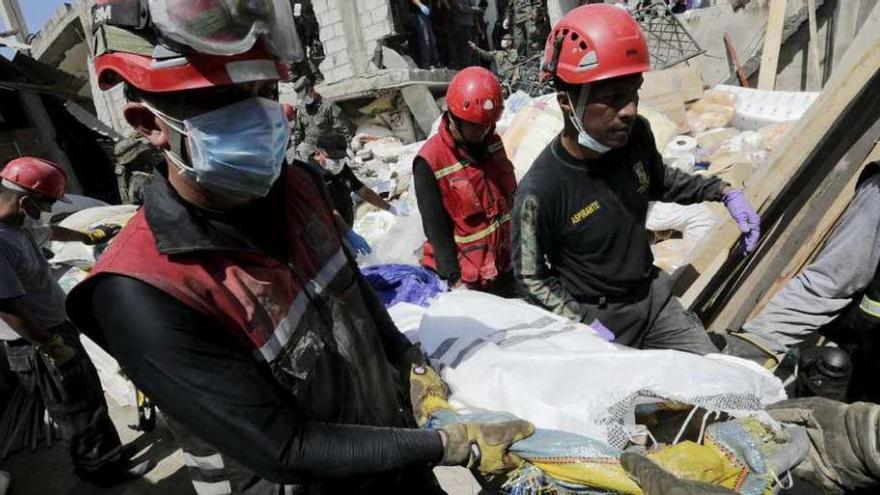 Uno de los equipos de rescate retira un cuerpo de entre los escombros en Pedernales. // Reuters