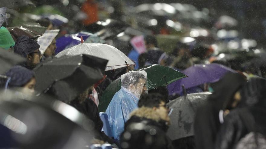 Un grupo de aficionados bajo la lluvia. // R. Grobas