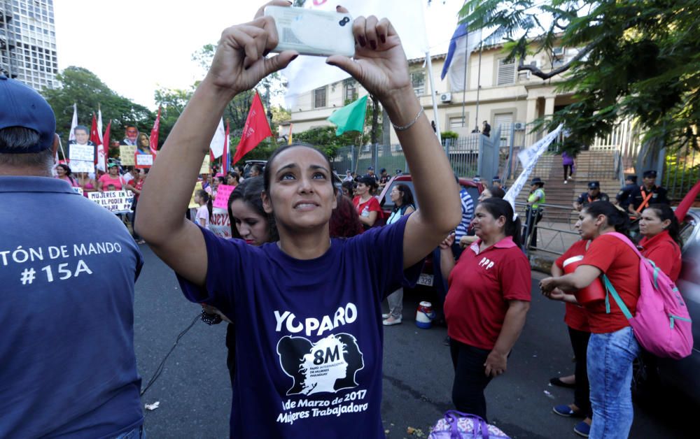 A woman takes a selfie during a protest by ...