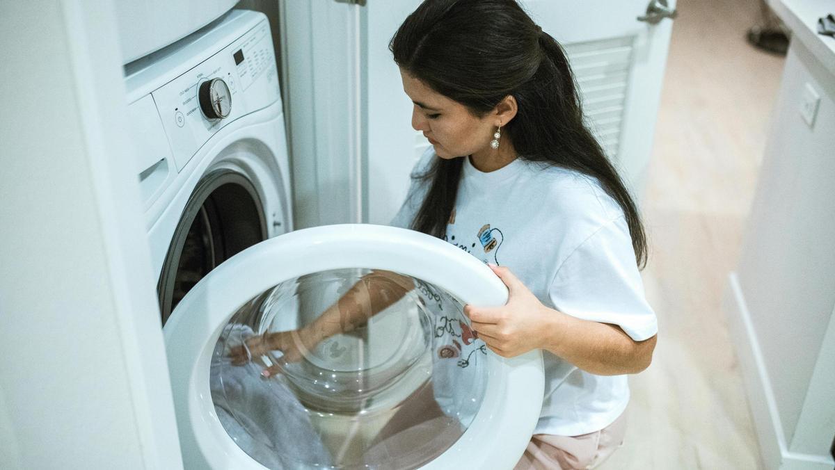 Una mujer poniendo la lavadora.