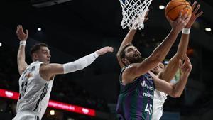 El pívot búlgaro del Unicaja David Kravish (c) entra a canasta ante la defensa de los jugadores del Real Madrid este domingo, durante un partido de baloncesto de la Liga Endesa, entre el Real Madrid y el Unicaja, en Madrid. EFE/ Daniel González