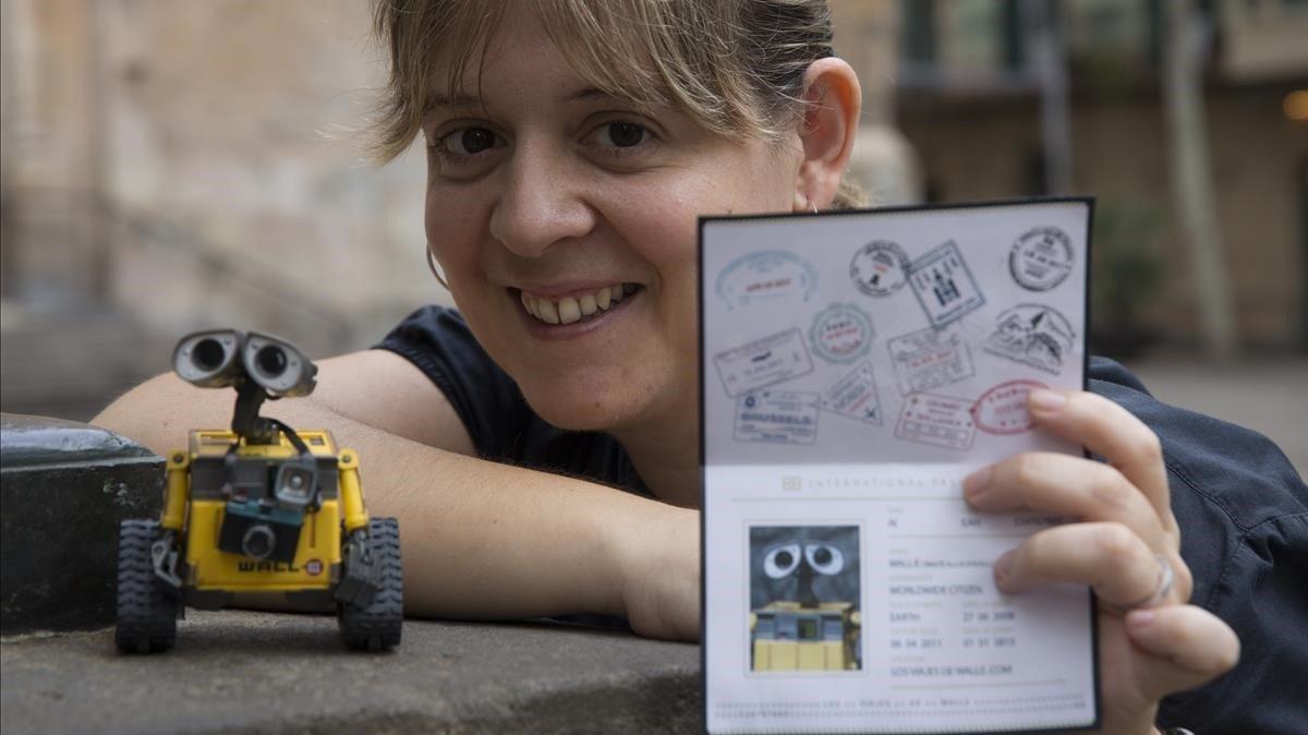Júlia Vázquez enseña el pasaporte de su Wall-E viajero. A su derecha, el muñeco trotamundos con cámara al cuello. Júlia Vázquez enseña el pasaporte de su Wall-E viajero. A su derecha, el muñeco trotamundos con cámara al cuello.