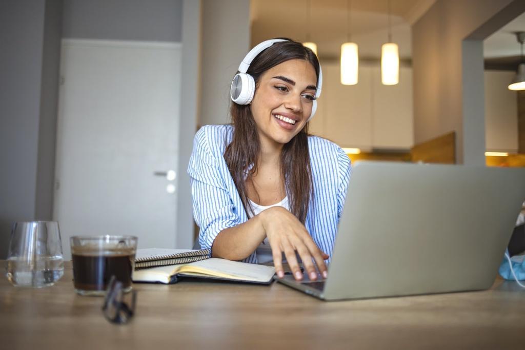 Chica sonriente estudiando con su ordenador en casa