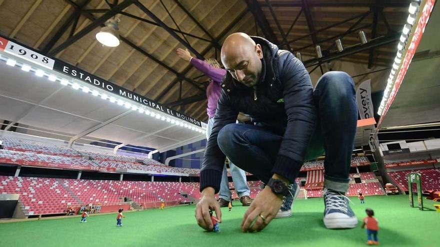 Abelardo, con Javier Grela detrás, coloca los muñecos del Sporting sobre el terreno de juego del Playumobil.