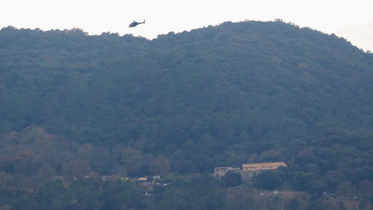 Un helicóptero sobrevuela la casa rural Can Serrallonga intentando localizar al pequeño que se perdió ayer jueves en la zona