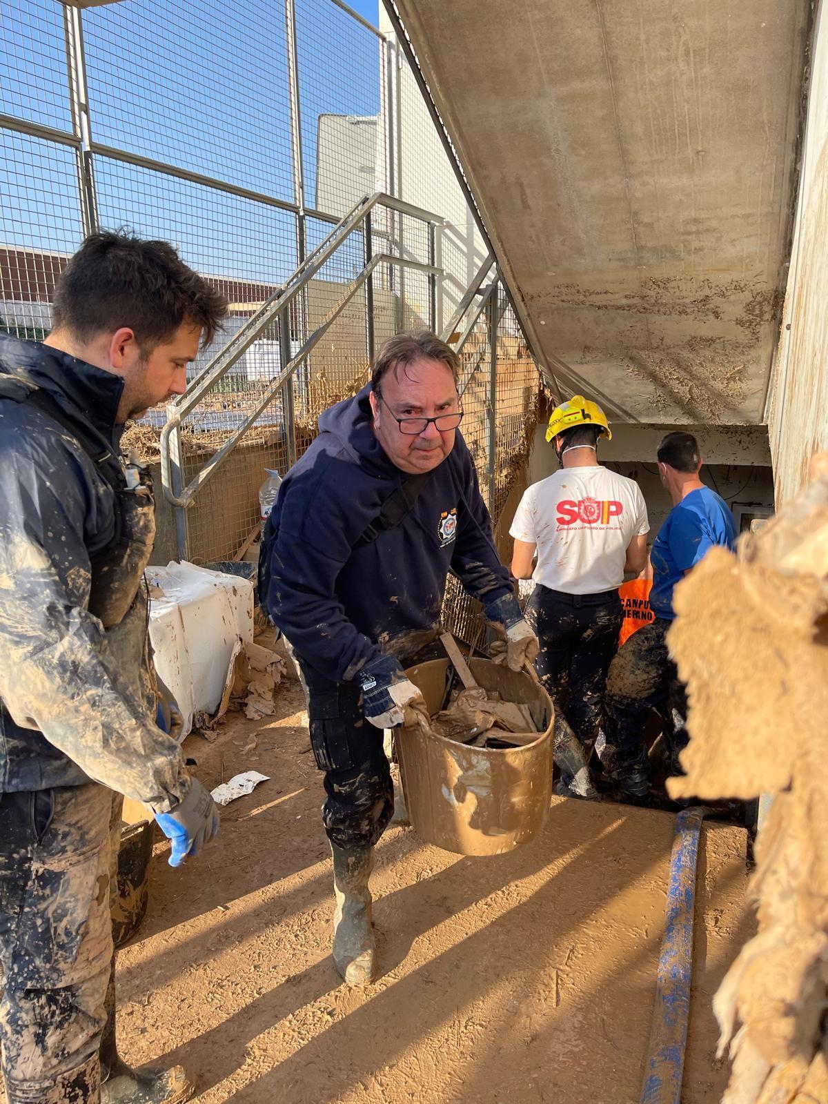 Los agentes mallorquines, durante los trabajos de limpieza en el polideportivo de Massanassa.