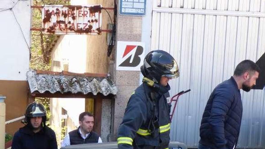 Bomberos y trabajadores de la funeraria salen con el cuerpo del callejón que da acceso al río.