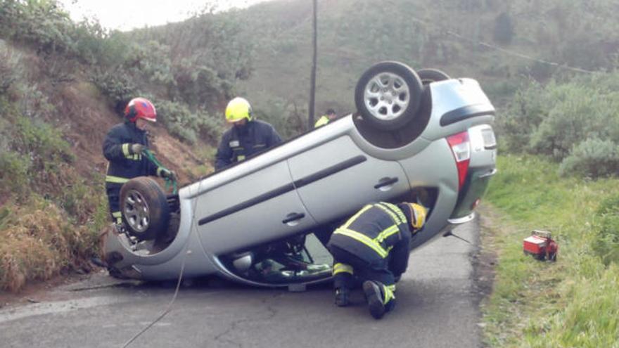 Bomberos actúan tras el vuelco del vehículo.