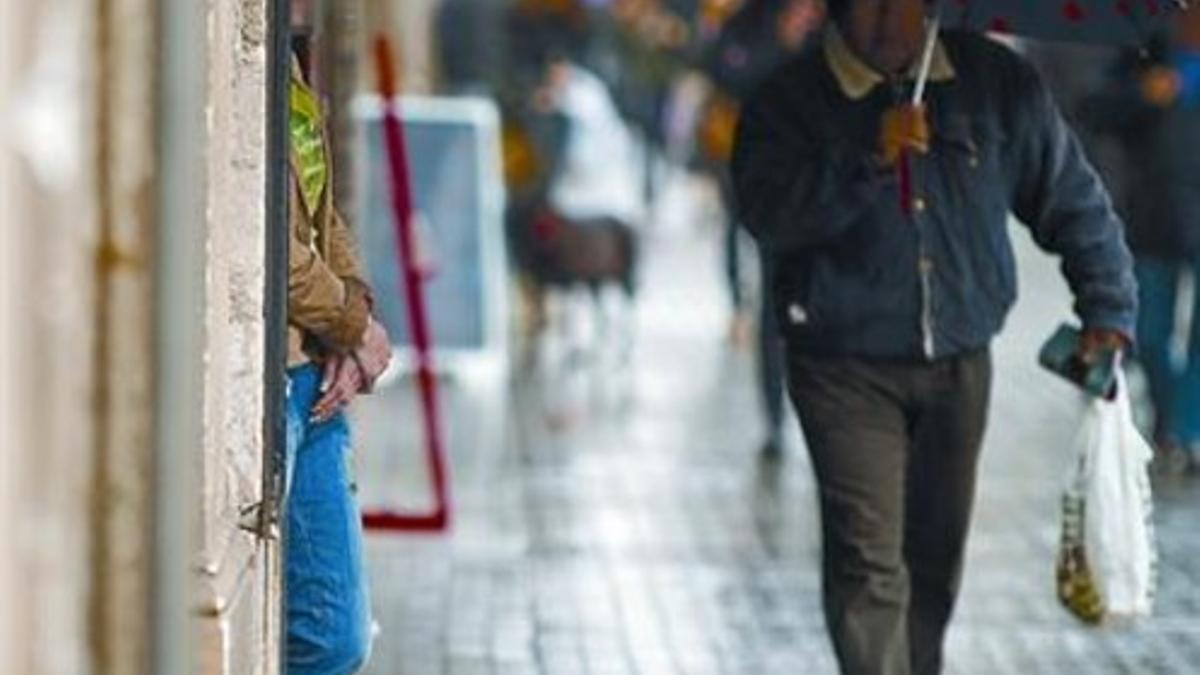 En la calle 8 Una mujer aguarda en un portal de la ronda de Sant Antoni, ayer por la mañana.