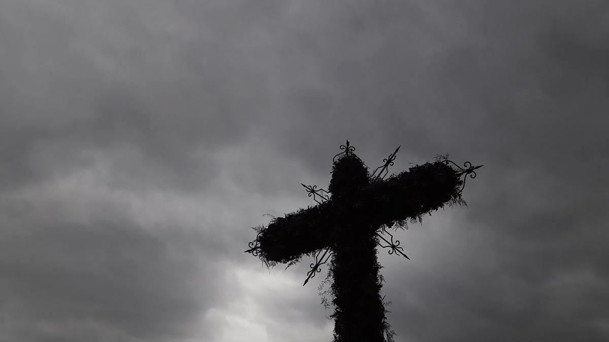Cruz de mayo bajo un cielo nublado.