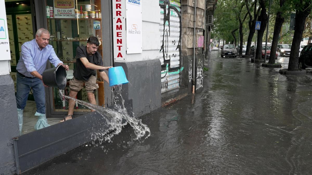 Los ciudadanos de Catania evacuan agua de sus casas y negocios.