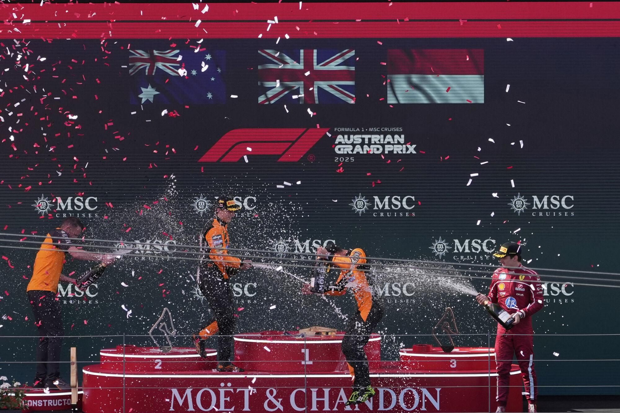 From the left, second-placed McLaren driver Oscar Piastri of Australia, fist-placed McLaren driver Lando Norris of Britain, and thrid-placed Ferrari driver Charles Leclerc of Monaco celebrate on the podium during the Austrian Formula One Grand Prix in Spielberg, Austria, Sunday, June 29, 2025. (AP Photo/Darko Bandic)