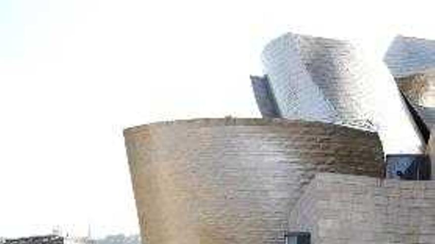 Miembros de la organización Amigos del Museo Guggenheim Bilbao sostienen unas piezas ligeras, simulando las placas de titanio que recubren la estructura del Museo Guggenheim Bilbao, con motivo de su participación en la iniciativa denominada &quot;AdosAdos&quot; e ideada por la artista donostiarra Maider López. Los participantes han conseguido, desde una perspectiva aérea, crear una nueva galería en el museo, a la manera de los batallones, que juntando sus escudos construían arquitecturas defensivas, y también formar una nueva pared, efímera, que daba continuidad al edificio de Ghery.