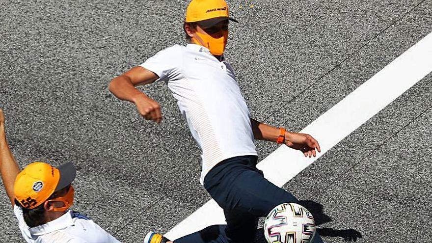 Carlos Sainz celebra con Lando Norris y un balón de fútbol la vuelta de Alonso