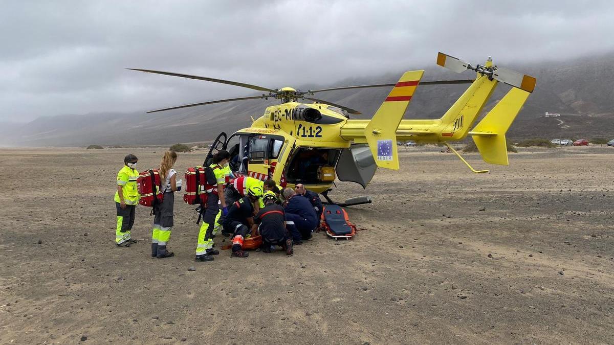 Los bomberos y sanitarios durante el traslado del menor de edad en Cofete.