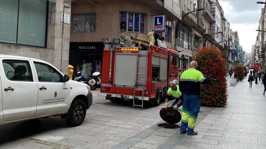 Operarios y bomberos, frente a la tienda de Rosa Clará // FdV