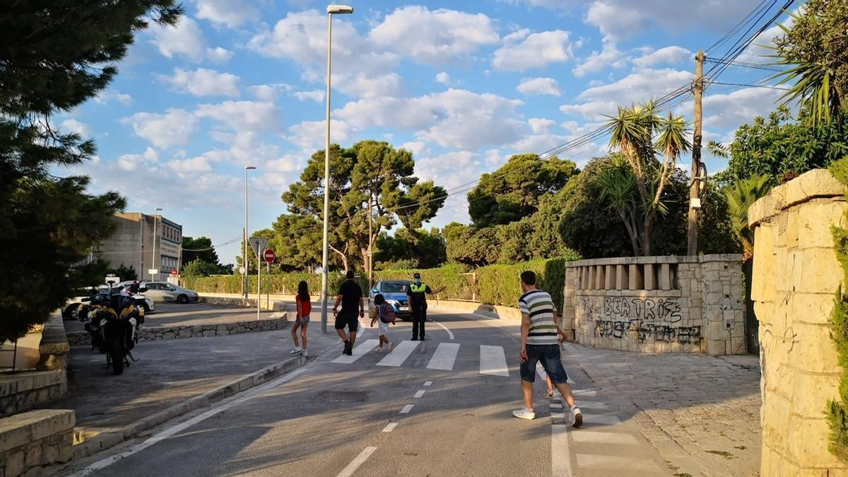 Un policía facilita el paso a personas en el entorno de un colegio de Alicante