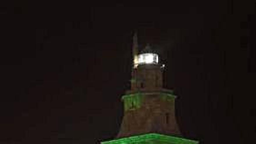 La Torre de Hércules, de noche, iluminada de verde.