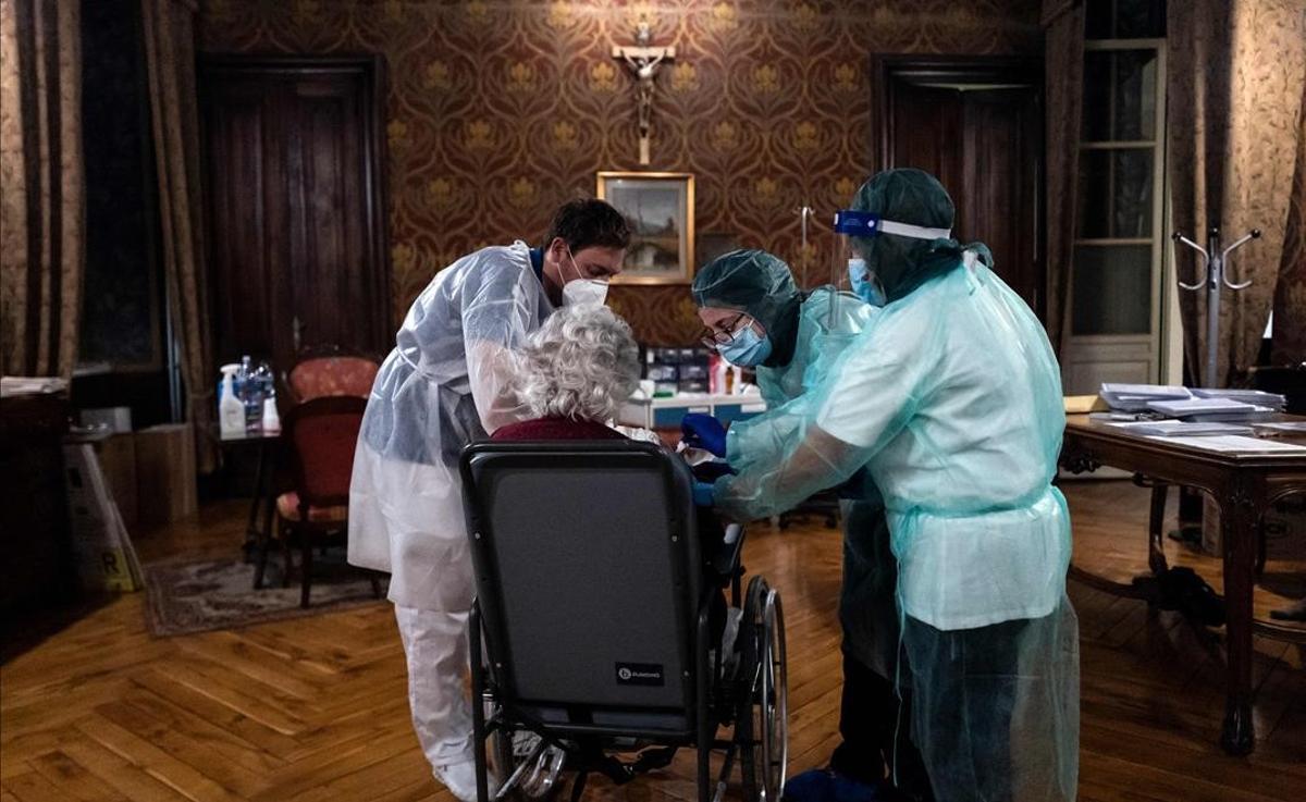Una anciana recibe la vacuna del covid de Pfizer-BioNTech en el asilo Tapparelli de la ciudad italiana de Saluzzo.