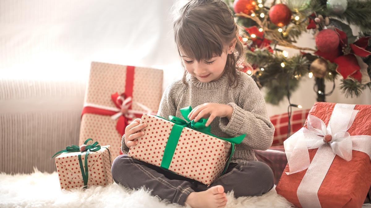 Una niña desenvuelve su regalo.