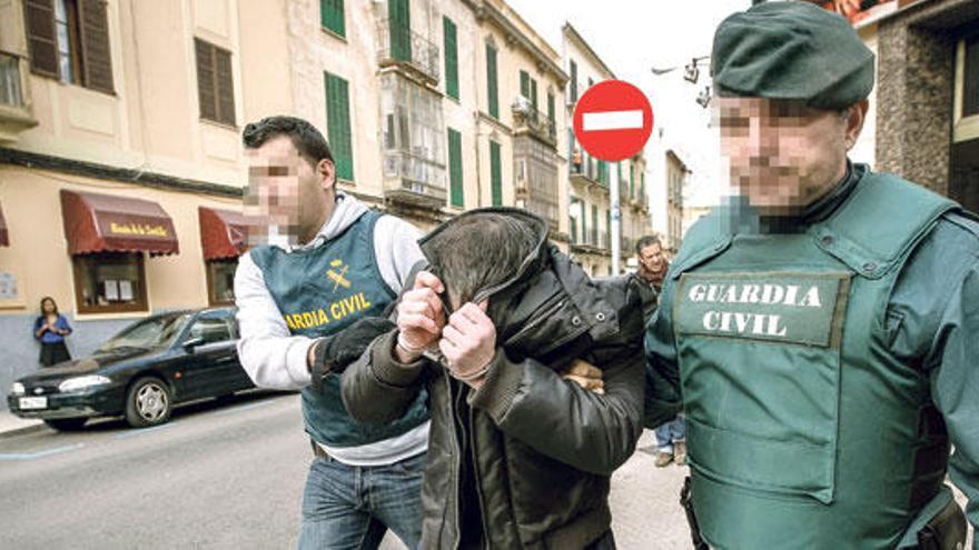 Dos agentes de la Guardia Civil custodian a uno de los detenidos durante uno de los registros realizados el miércoles en Palma.