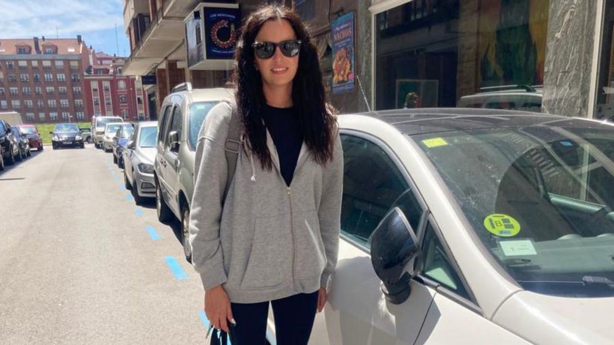 María Cangas, junto a su vehículo, con la pegatina, en la calle Matadero Viego, ayer por la mañana. | M. L. 