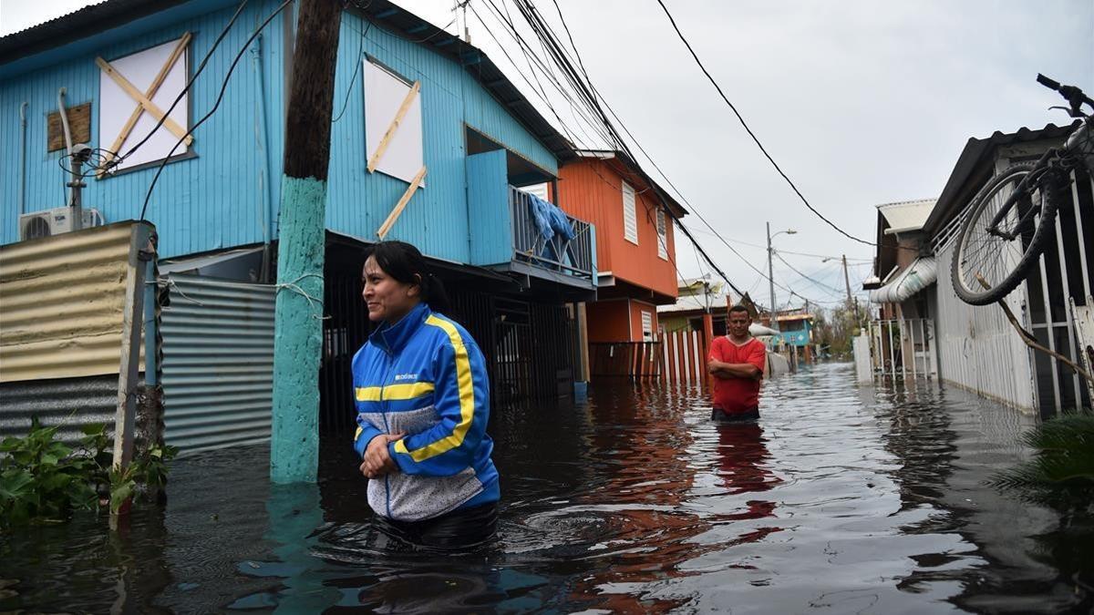 Dos personas caminan por una calle inundada en Juana Matos (Puerto Rico), el 21 de septiembre.