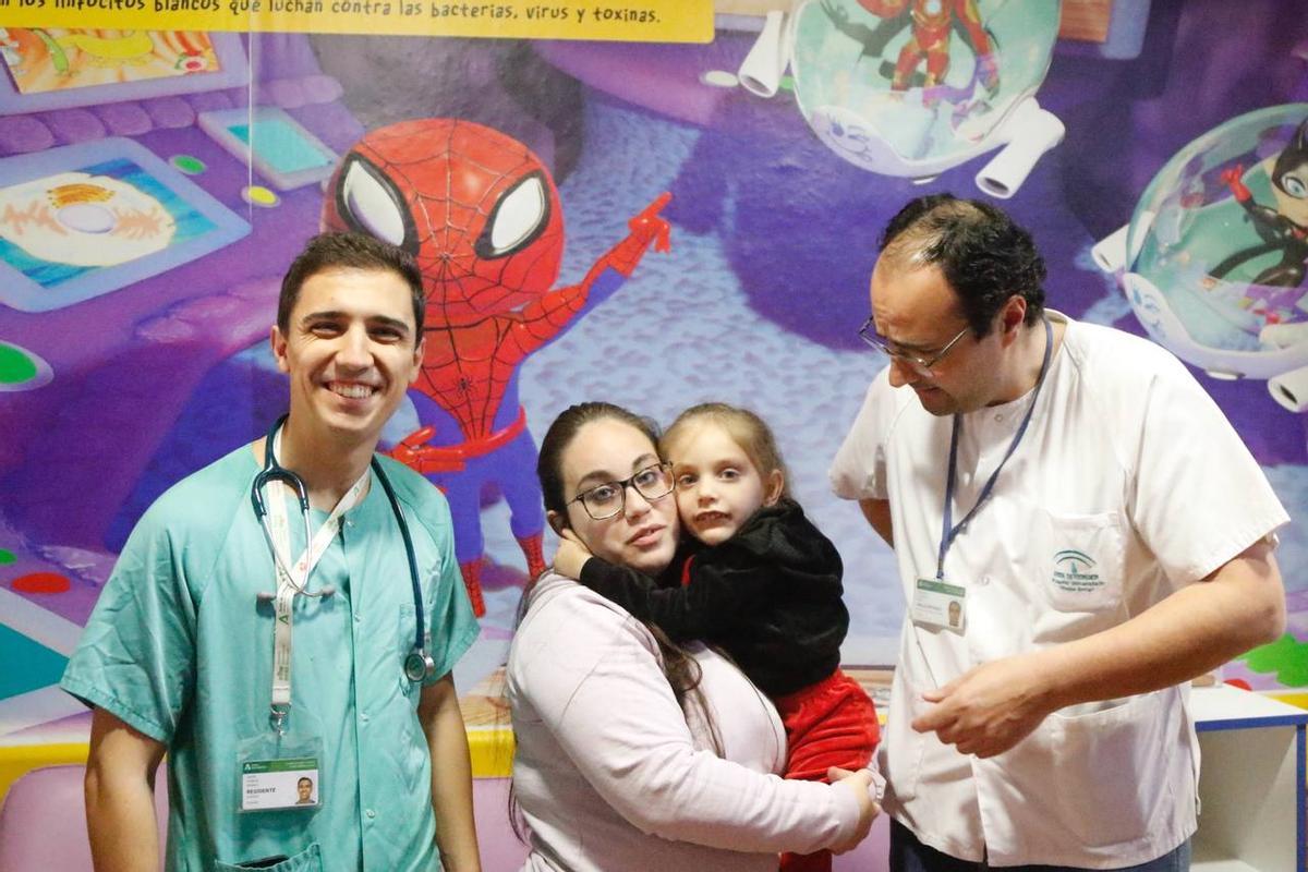 Cinthia, con su hija Thalía, en el centro, junto a dos doctores en el hospital Reina Sofía.