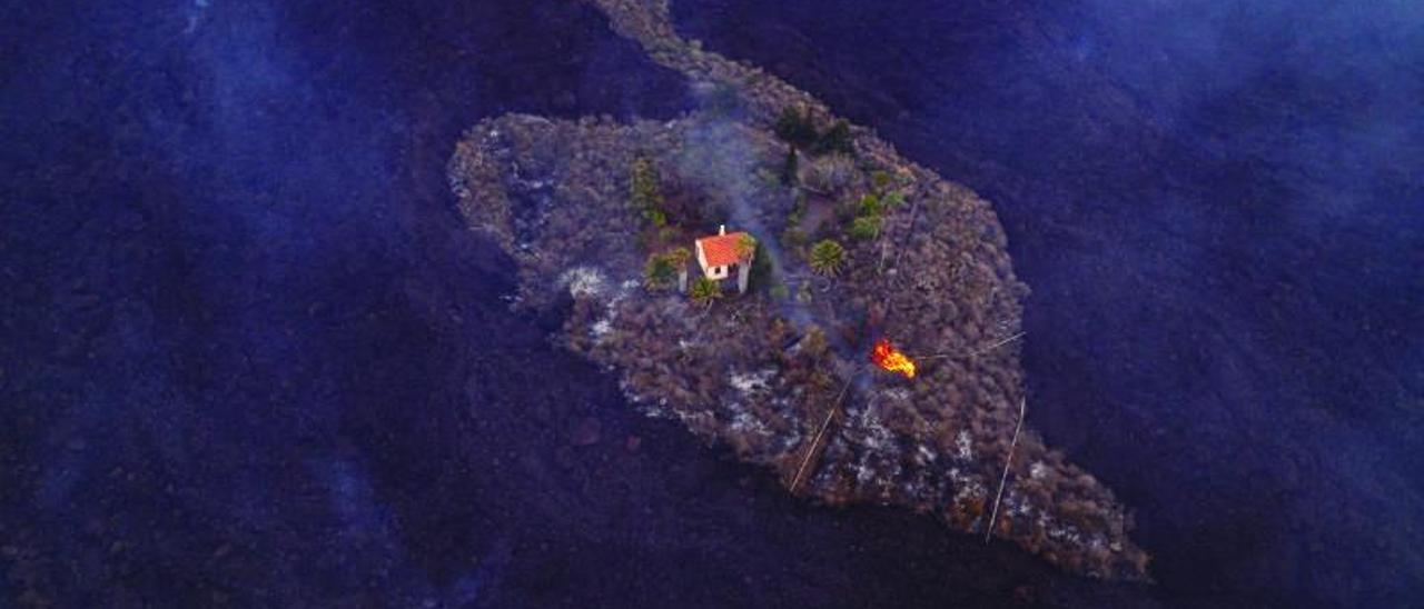 Esta fotografía de una vivienda que sobrevive de forma milagrosa a las coladas de la erupción de La Palma dio ayer la vuelta al mundo.