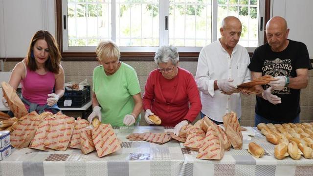 Voluntarios del proyecto, ayer, preparan comida en el local de la iglesia del Perpetuo Socorro.   | // ALBA VILLAR
