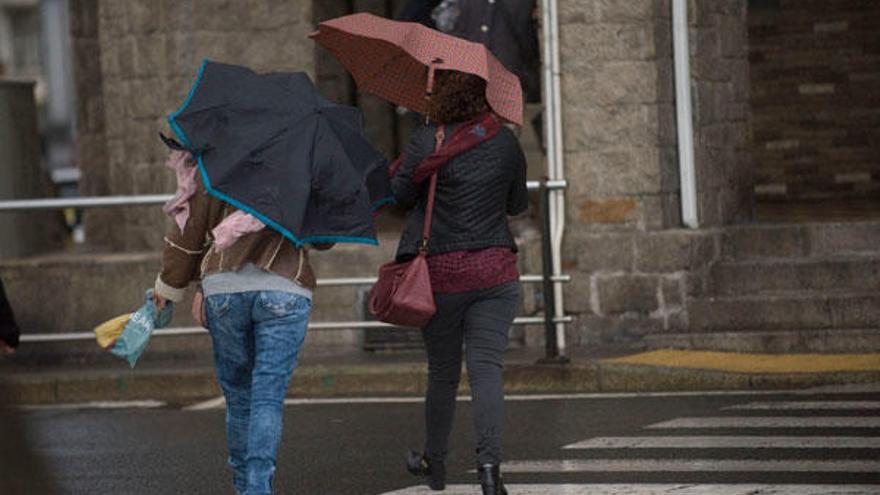 Dos personas con paraguas en Riazor.