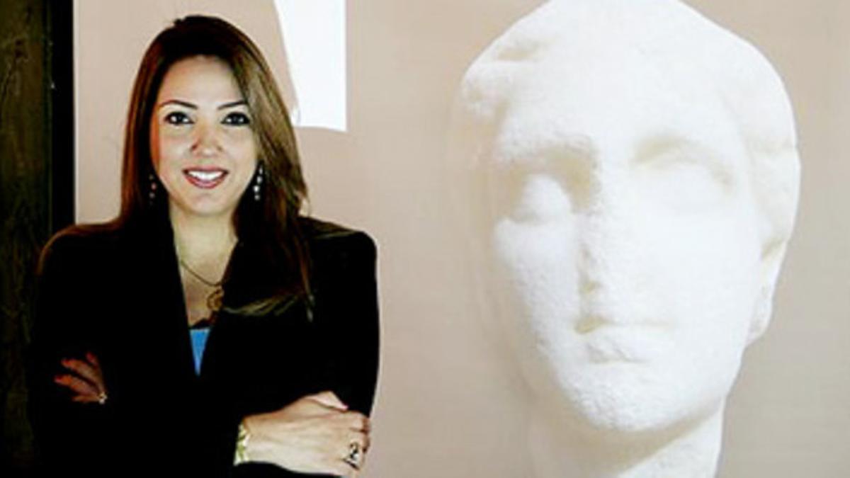 La egiptóloga dominicana Kathleen Martinez posa junto a la imagen de la supuesta cabeza de Cleopatra.