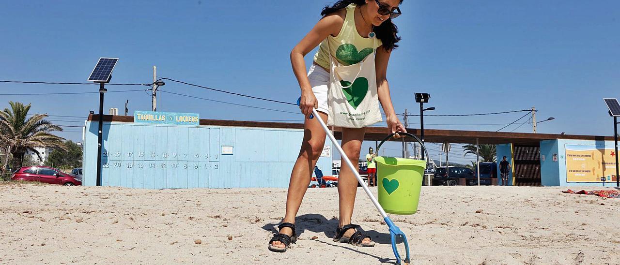 Una voluntaria de Casita Verde busca objetos en la arena.