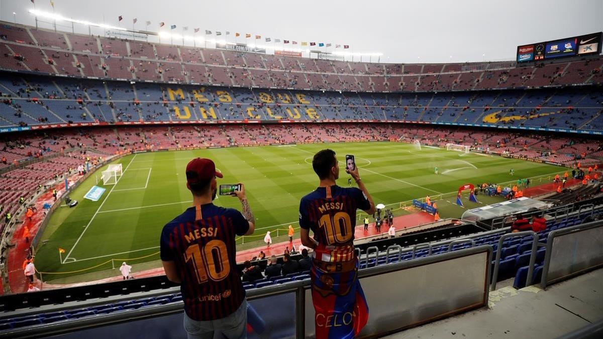 Dos aficionados fotografían el interior del Camp Nou