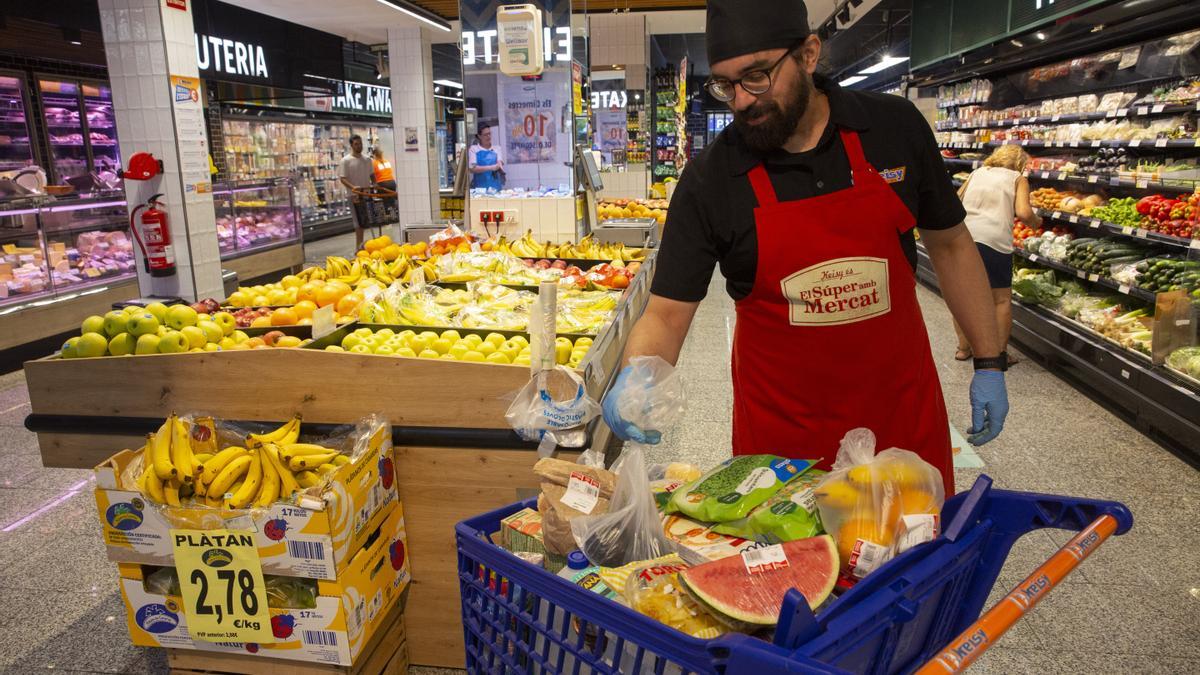 Un trabajador de un supermercado prepara un carro de la compra.