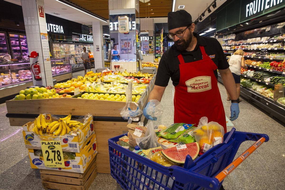 Un trabajador de un supermercado prepara un carro de la compra.