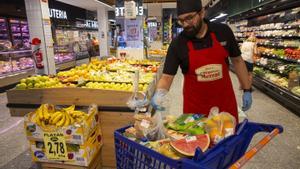 Un trabajador de un supermercado prepara un carro de la compra.