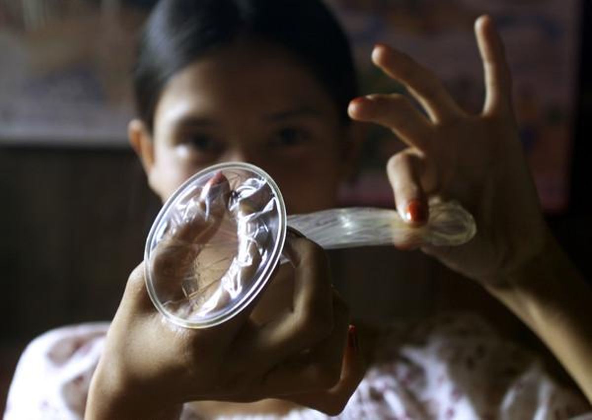 Una dona sosté un preservatiu femení.
